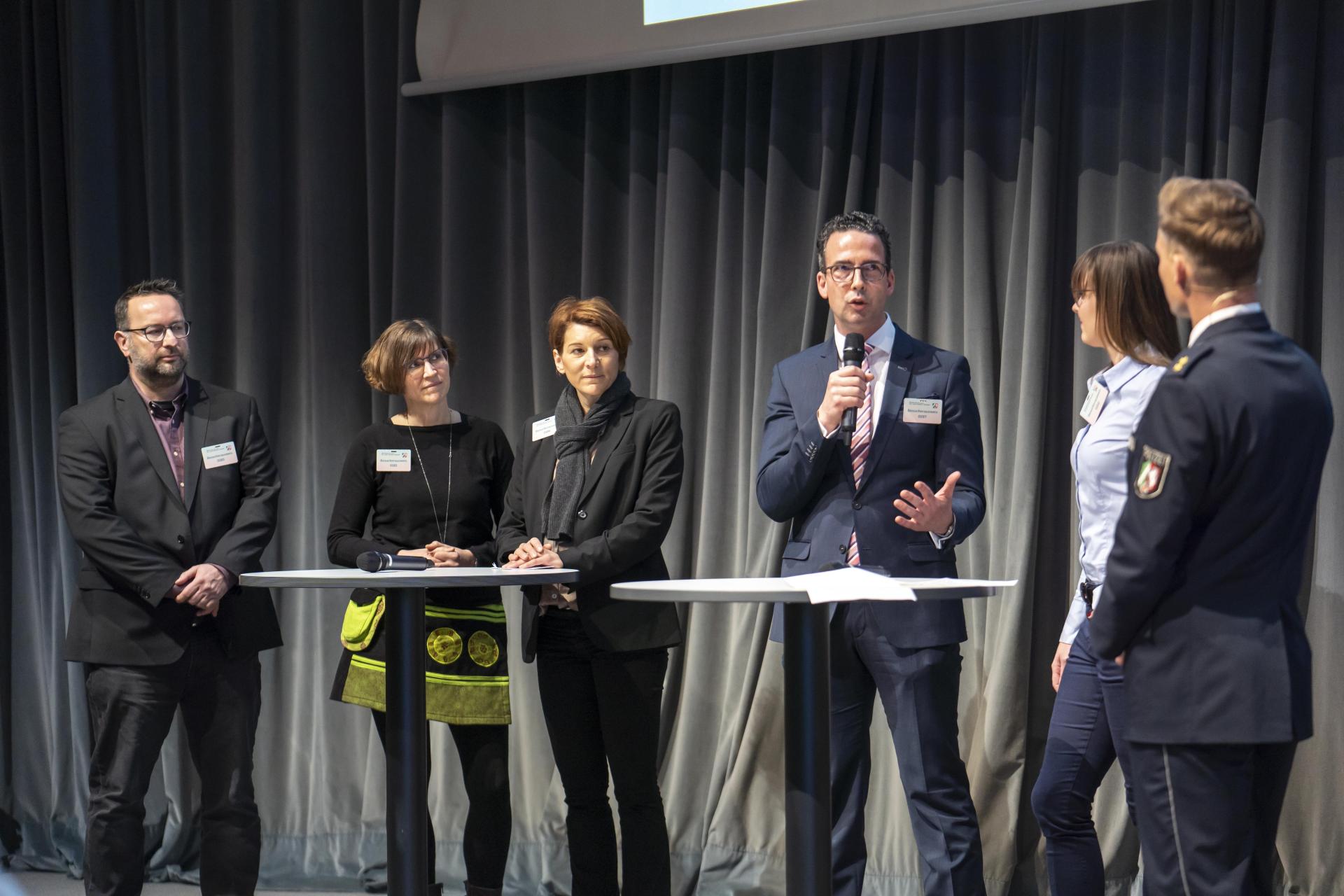 Marcus Rüsche, Britta Fast und Vera Hachmann (Steuerfahndung Münster) und Prof. Dr. Marc Busche und Jessica Odenthal (Klinikum Leverkusen) berichten zu erfolgreichen Trainings von Deeskalation und Eigenschutz in gefährlichen Situationen. 